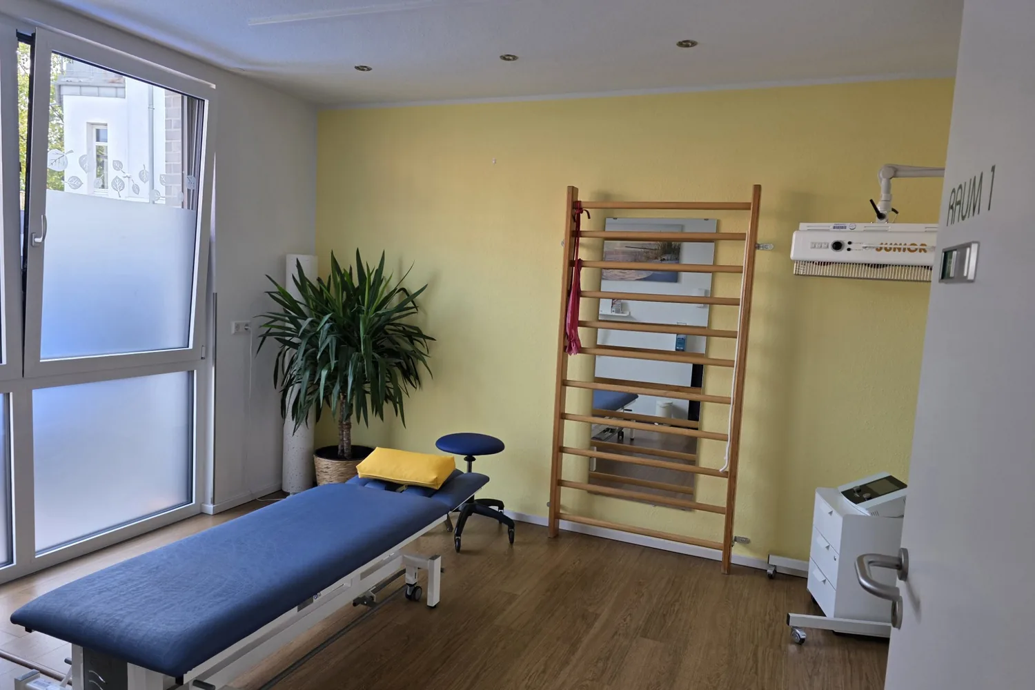 Behandlungsraum 1 mit Therapieliege und Sprossenwand