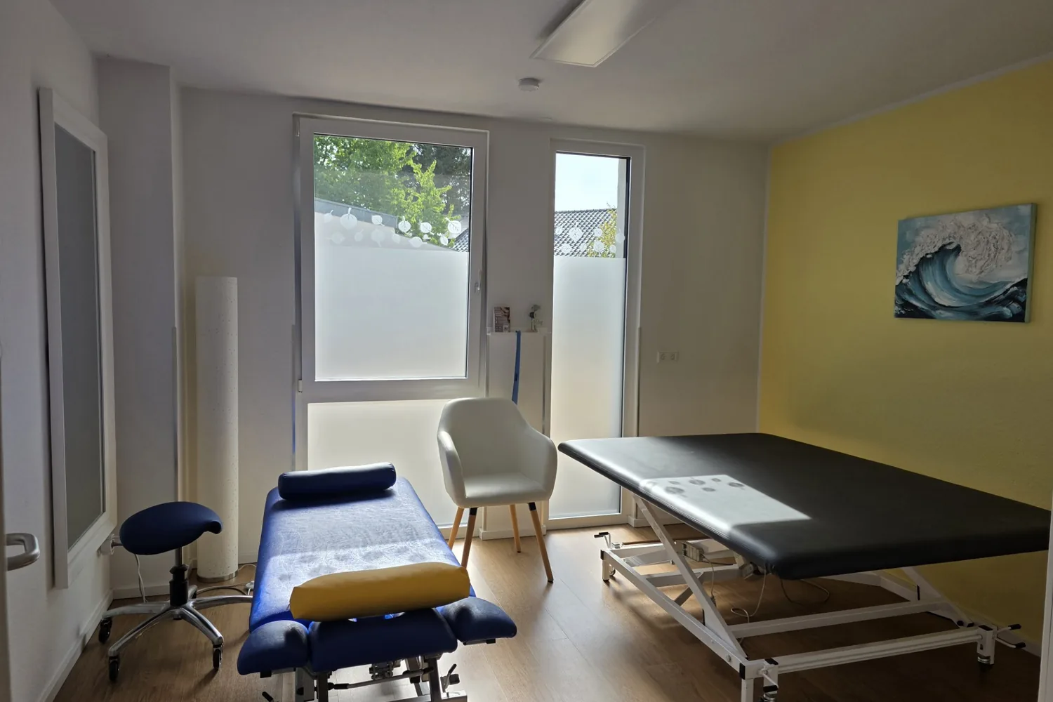Behandlungsraum mit Therapieliegen und Sessel