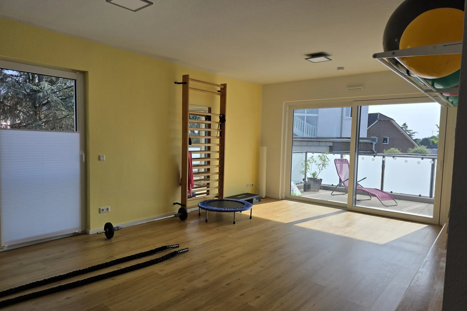Heller Bewegungsraum mit Sprossenwand, Trampolin und Balkon