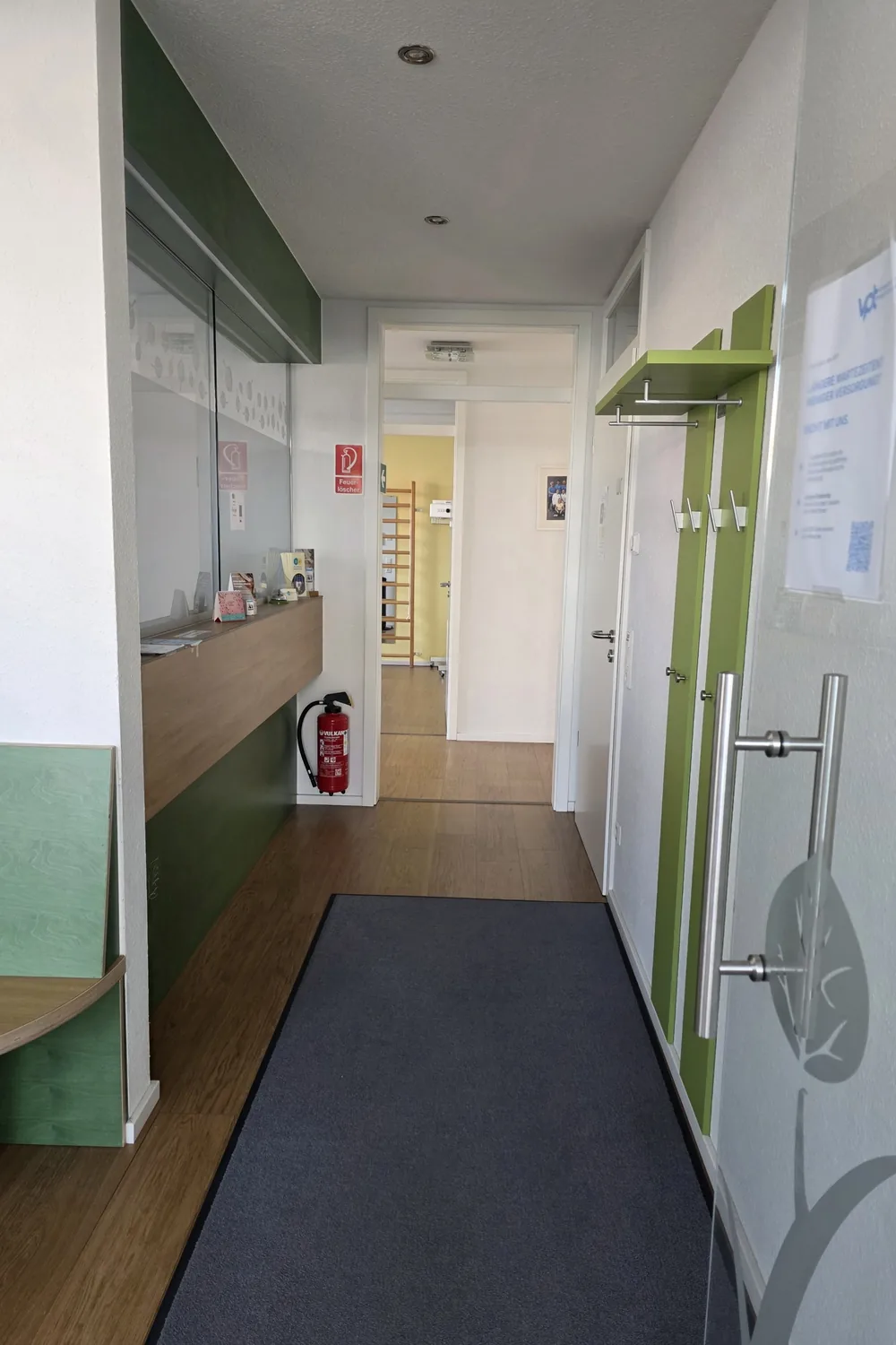 Empfang mit Garderobe und Blick in einen Behandlungsraum