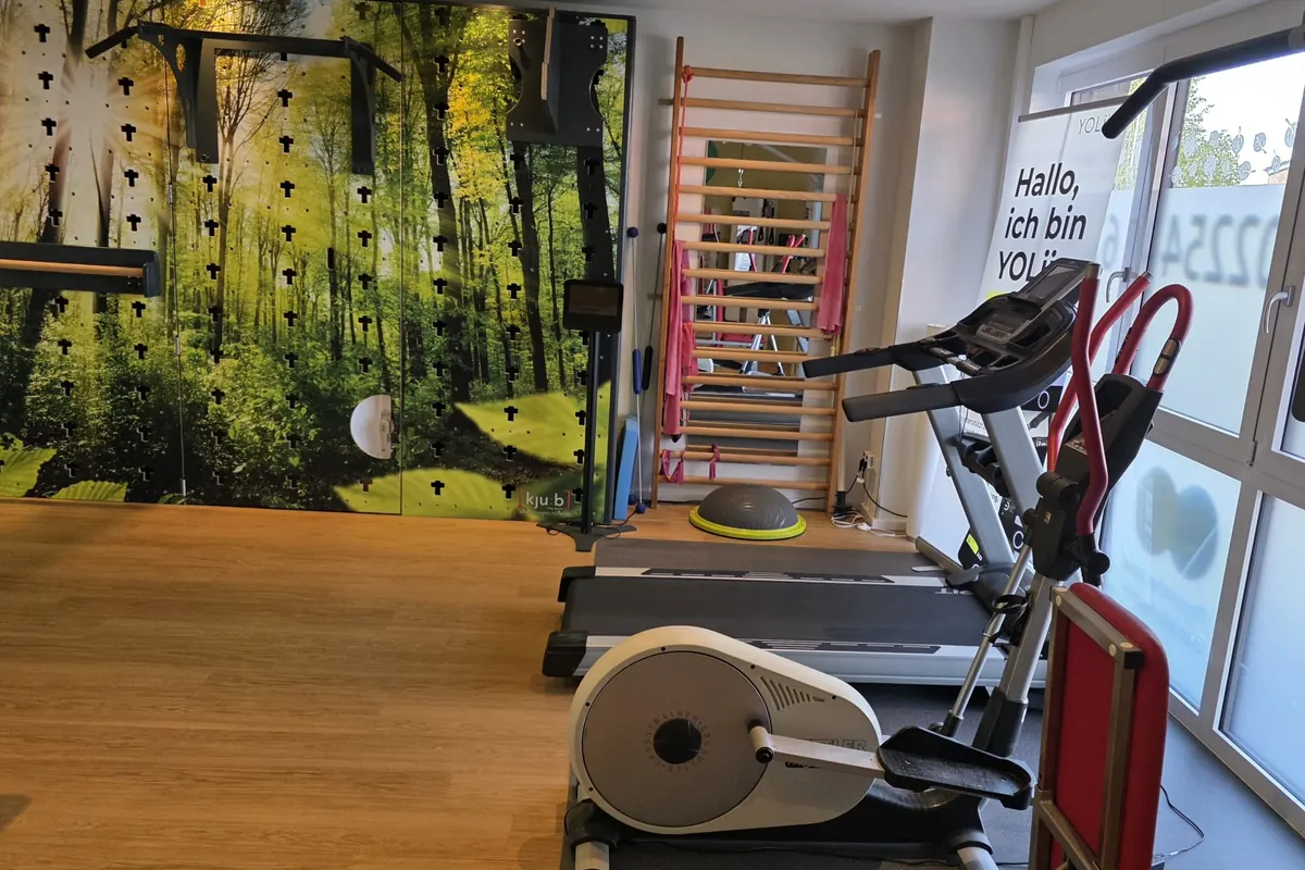 Laufband und Crosstrainer vor der Cube-Funktionswand