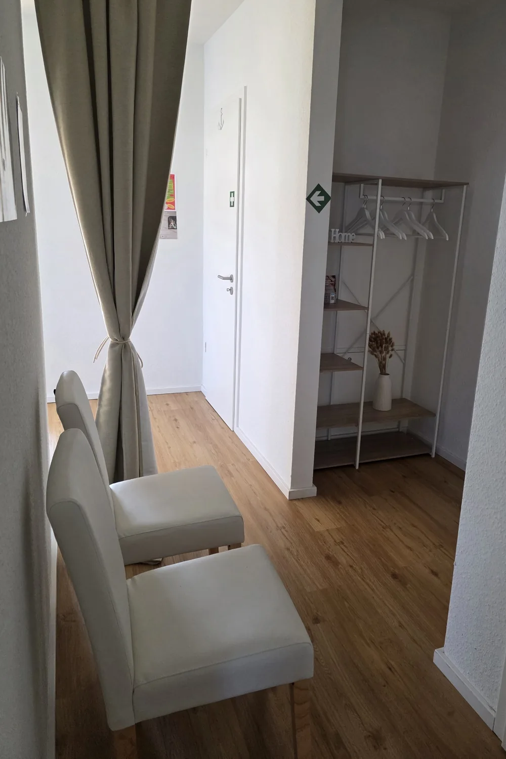 Warteecke mit zwei Stühlen und Garderobe